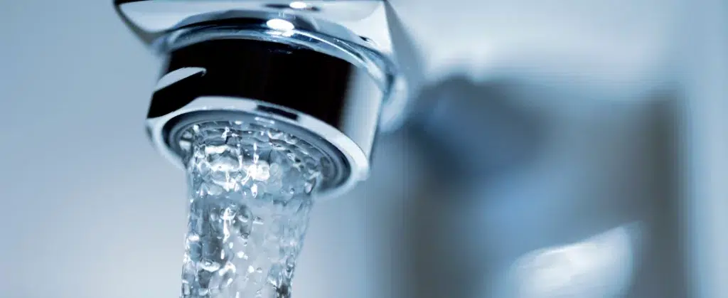 Stock photo of a faucet running from canva for our frozen pipes blog post